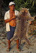 Local hunter with Ocelot skin {Leopardus / Felis pardalis} poached in the forest, Amazonas, Brazil, September 2007