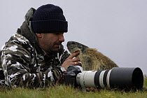 Photographer, Grzegorz Lesniewski with curious marmot, model released, Hohe Tauern National Park, Austria, July 2008