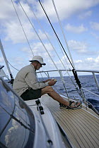 Man relaxing with a book aboard Amel 54 "Hollis" on delivery from Martinique, Caribbean. Model Released & property released. 2006.