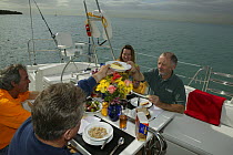 Friends eating breakfast aboard Stephens 53 in Florida Bay, Florida, USA.  Model and property released.