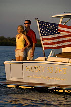 Couple aboard Surf Hunter 33 Jet boat off Marco Island, Florida. Model and property released.
