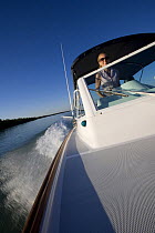 Woman helming Hunt Harrier 25 off Marco Island, Florida, USA. Model and property released, 2007.