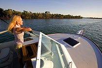 Woman looking over the wind shield aboard Hunt Harrier 25, cruising off Marco Island, Florida, USA. Model and property released, 2007.