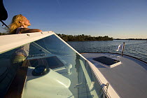 Woman looking over the wind shield aboard Hunt Harrier 25, cruising off Marco Island, Florida, USA. Model and property released, 2007.