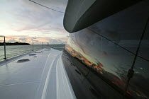 Sunset reflections in cabin window aboard Foutaine Pajot Eleuthra 60 catamaran off Miami, Florida, USA.