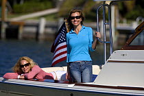 Women in the cockpit of a Surf Hunter 29 Inboard off Marco Island, Florida, USA. Model and property released, 2007.