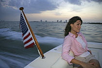 Woman sitting in the stern of a Hunt Harrier 25 off Hollywood, Florida, USA. Model and property released.