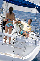 Couple cruising onboard a Sunsail Oceanis 423, British Virgin Islands. Model released and property released, March 2006.