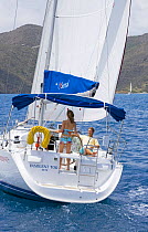Couple cruising on Sunsail Oceanis 423 yacht "Insolent Too", British Virgin Islands. Model released and property released, March 2006.