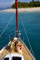 Couple relaxing on the bow of a yacht in the British Virgin Islands, Caribbean. Model released, March 2006.