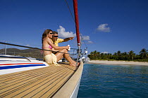 Couple relaxing on the bow of a yacht in the British Virgin Islands, Caribbean. Model released, March 2006.