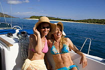 Two women relaxing on a yacht in the British Virgin Islands, Caribbean. Model released, March 2006.