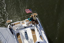 Couple relaxing on stern of Hunter 49 yacht off St. Augustine, Florida, USA.  Model and property released.
