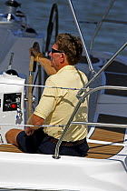 Man helming a Hunter 49 yacht off St. Augustine, Florida, USA.  Model and property released.