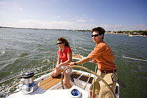 Couple aboard Hunter 49 yacht off St. Augustine, Florida, USA. Model and Property released, 2006.