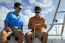 Father teaching his son how to tie a knot aboard a Hunter 49 yacht off St. Augustine, Florida, USA. Model and Property released, 2006.