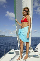 Girl in bikini on board Lagoon 470 Sunsail charter catamaran "KooLau", anchored off the British Virgin Islands, January 2004. Model released.