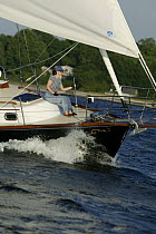 Woman on foredeck of Shannon 42 yacht sailing in Narragansett Bay, Newport, Rhode Island. June 2005, Model released.