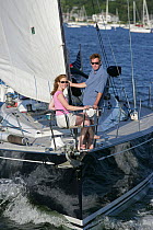 Couple in pulpit of Swan 60 "Extraordinary", sailing on Narragansett Bay, Rhode Island. Model Released, July 2005.