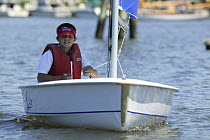 Boy sailing Hunter dinghy "Excite" near Mystic Seaport in Mystic, Connecticut, USA. Model released, August 2004.
