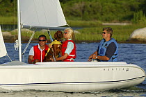 Friends and a dog sailing a Hunter 146 dinghy near Mystic, Connecticut, USA. August 2004.  Model and property released.