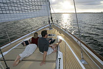 Couple on foredeck of 80ft. Oyster "Darling". Narragansett Bay, Newport, Rhode Island, September 2005. Property released.