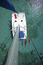 Kayak, snorkeler and open kayak viewed from the masthead of Moorings charter catamaran "Pitch Pin", British Virgin Islands. January 2004. Model and property released.