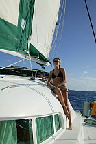 Girl in bikini aboard Lagoon 470 Sunsail charter catamaran "KooLau", British Virgin Islands, January 2004. Model and property released.
