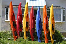 Colourful kayaks lined up on a stand, July 2003.