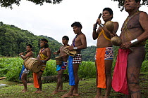 Embera Indian men dressed in traditional clothing greeting their guests with music, rainforest, Panama, November 2008