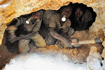 Young men holding their torches in their mouth while digging 10 meters underground in the coltan mines of Muhanga, Rwanda. This mineral is radioactive and these young miners are killing their lungs by...