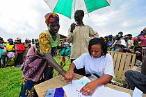 Woman registering for food aid distributed by charities at Kibati village refugee camp, north of Goma, North Kivu, Democratic Republic of Congo, Africa, March 2009