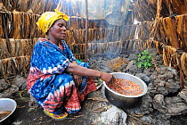 Woman cooking in her tent at the refugee camp Mugunga 1, west of Goma, North Kivu, Democratic Republic of Congo, Africa, March 2009