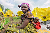 Woman and her children in front of their tent at the Lac Vert refugee camp, west of Goma on the road to Sake, North Kivu, Democratic Republic of Congo, Africa, March 2009