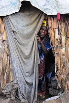Woman peering out of her tent at the refugee camp Mugunga 1, west of Goma, North Kivu, Democratic Republic of Congo, Africa, March 2009