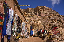 Tourists looking at goods for sale, Aït Benhaddou Kasbah UNESCO site, Morocco. November 2008.