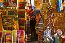 Man sitting outside his carpet shop in Essaouira town, Morocco, November 2008.