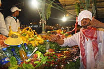 Chef selling fresh food in night souk, Djemaa el-Fna town square, Marrakech, Morocco. November 2008.