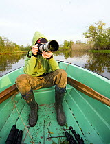 Young boy photographing from a boat on the Suur Emajogi, Palupohja Looduskool, Alam-Pedja nature reserve, Tartumaa, Estonia, May