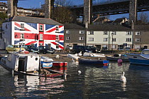Sinking boat, Saltash waterfront with the Union Inn pub and Brunel's Royal Albert (railway) Bridge. Cornwall, UK. April 2009.