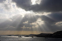 Sunshine through clouds over Tresco Channel, towards Bryher, with the Firethorn moored off Anneka's Quay. Isles of Scilly, December 2008.