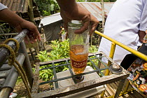 Putting fuel into the fuel tank of a 'skate' - a local form of transport in Manila, Philippines. A motorized platform that can hold up to 30 people and runs on the railway tracks. 2008
