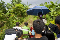 Commuters travelling on a 'skate' - a local form of transport in Manila, Philippines. A motorized platform that can hold up to 30 people and runs on the railway tracks. When the skate meets another head-on, the rule of the track is that the platform with fewer people get off the track and allow the other skate to pass, then go back on to the track and move on. 2008