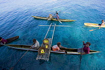 Papuans in traditional dug-out fishing canoes, Papua New Guinea. 2008