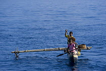 Papuans in traditional dug-out fishing canoe, Papua New Guinea. 2008