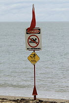 Warning signs on a beach in Australia, advising people not to swim in the water due to risk of jellyfish stings.