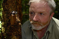 Dr. George McGavin in rainforest with Giant Longhorn Beetle (Cerambycidae), BBC Expedition Borneo, Sabah, Malaysia. April 2006.