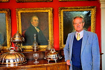 Peter de Sausmarez, here with his ancestor's portraits. His family has lived on the island since 1120 and he is the last seignior who still lives in his ancestral property: Sausmarez Manor and Gardens...