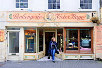 Woman leaving "Boulangerie Victor Hugo", St Peter Port, Guernsey, Channel Islands. May 2009.