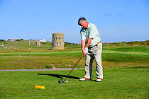 Man playing golf, Guernsey, Channel Islands. May 2009.